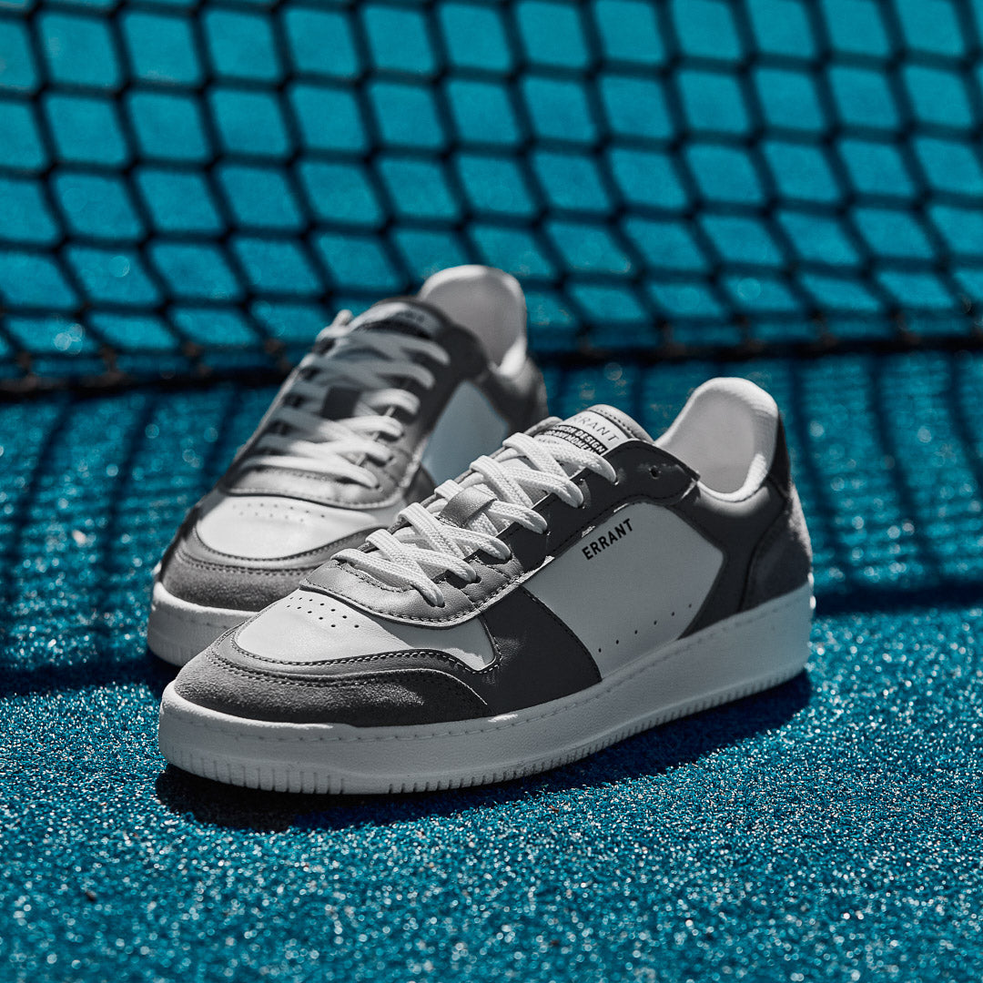Et par Low Sneaker - Grey på en blå tennisbane 