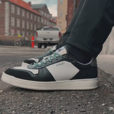 Mand går med et par Low Sneakers - Black Teal på en gade